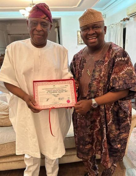 Senator Adeola presenting his Certificate of Return to Aremo Olusegun Osoba, former Governor of Ogun State.