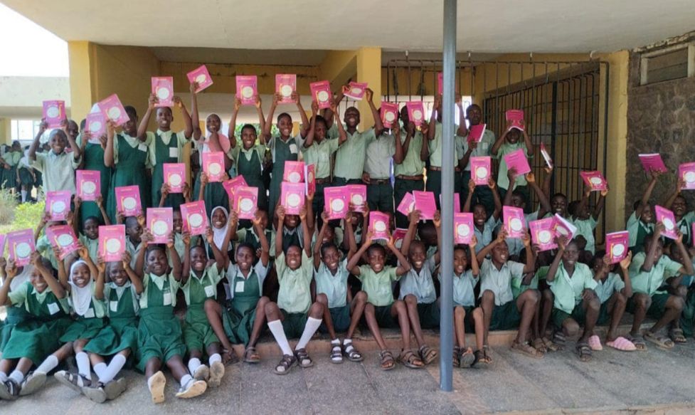 Students proudly displaying textbooks donated to their school by Senator Adeola.